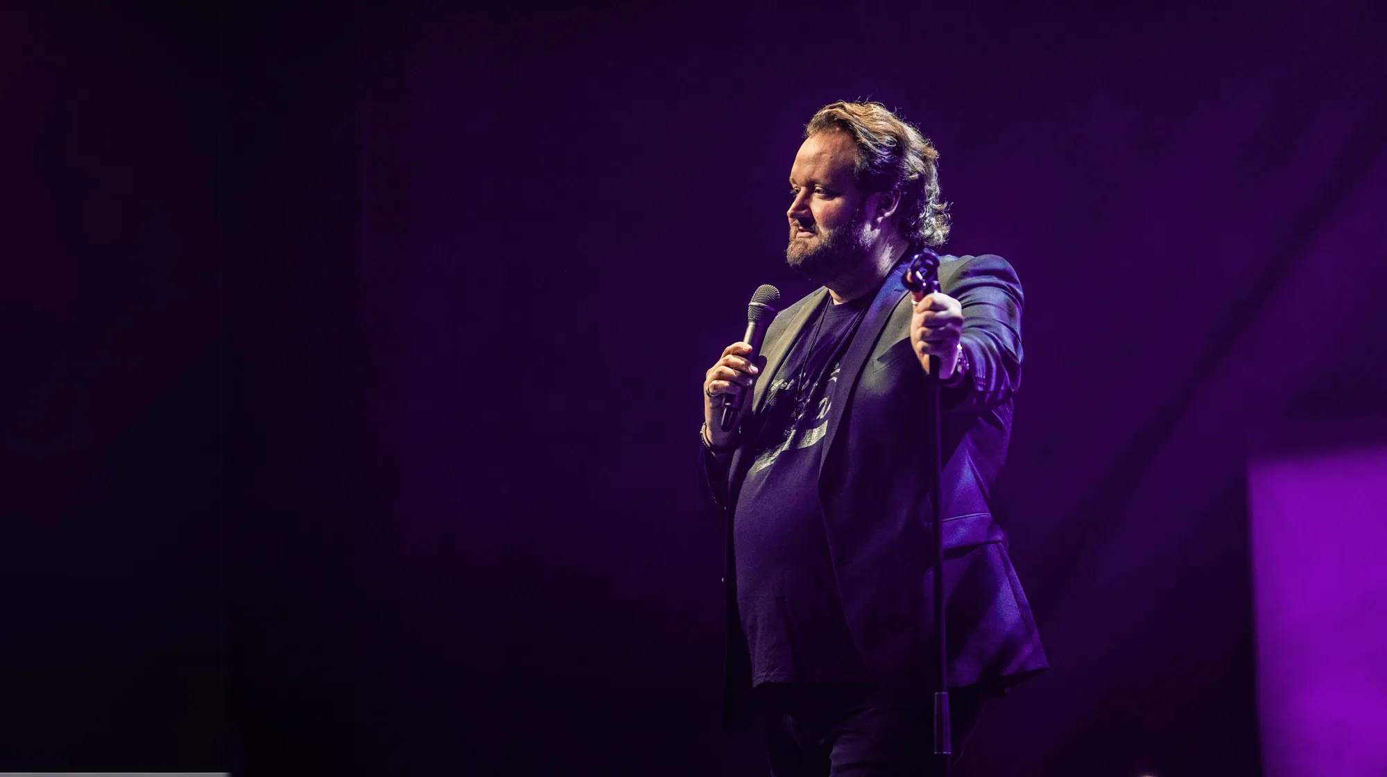 Sami Hedberg esiintyy mikrofonin kanssa violetiksi valaistulla lavalla
