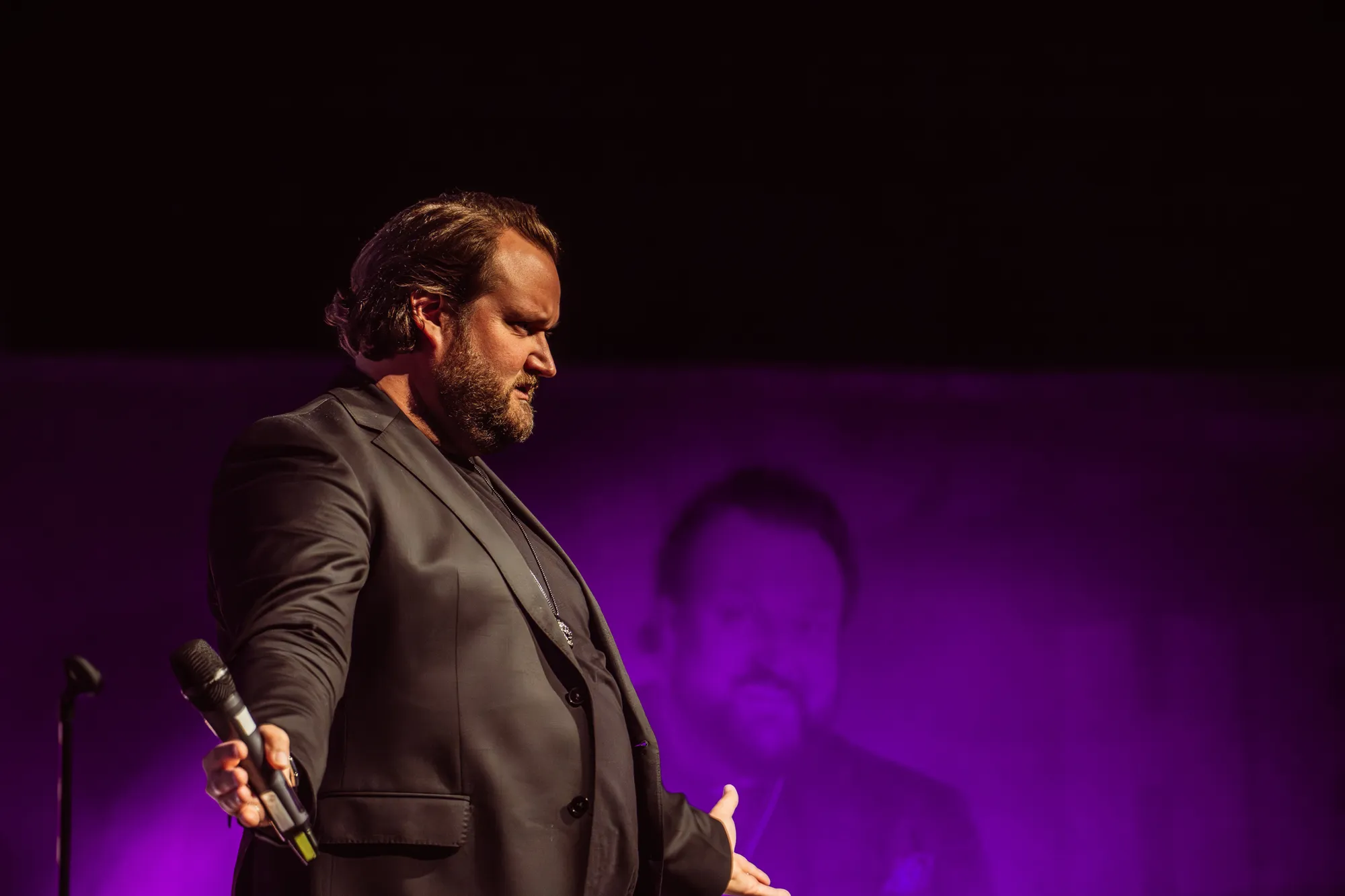Sami Hedberg mikrofonin kanssa violetiksi valaistulla lavalla