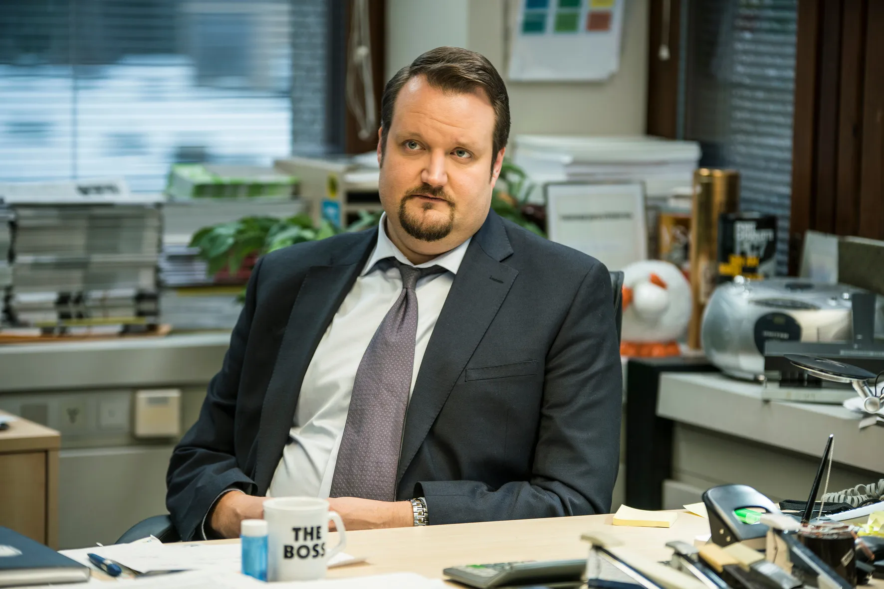 Sami Hedberg näyttelijän roolissa toimiston työpöydän äärellä