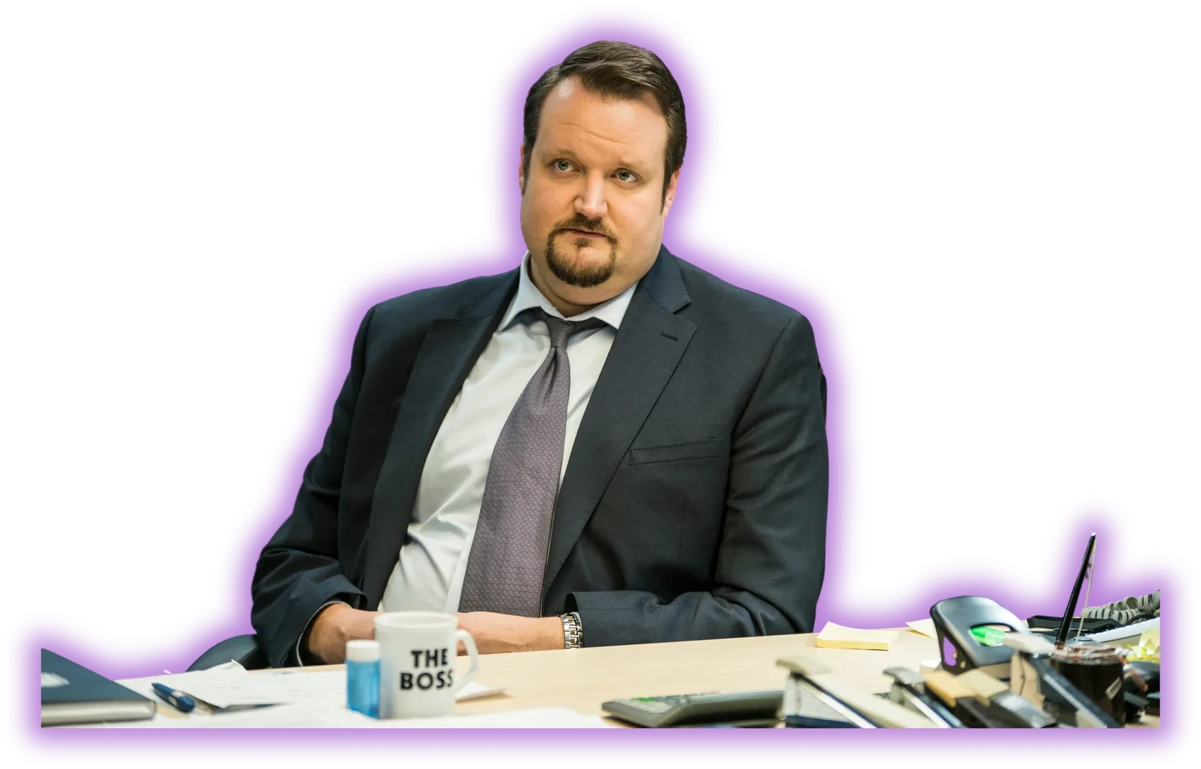 Sami Hedberg näyttelijän roolissa puvussa työpöydän äärellä